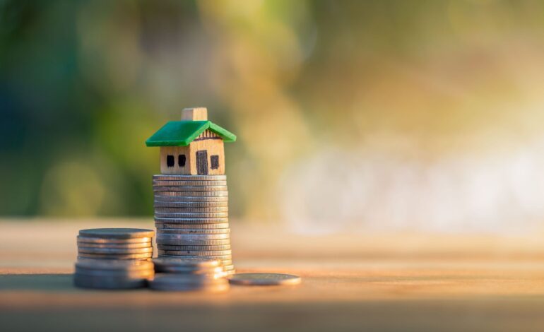 Dom umieszczony na monetach. planowanie oszczędności w monetach na zakup koncepcji domu, koncepcja drabiny nieruchomości, kredytu hipotecznego i inwestycji w nieruchomości. do oszczędzania lub inwestowania w dom.
