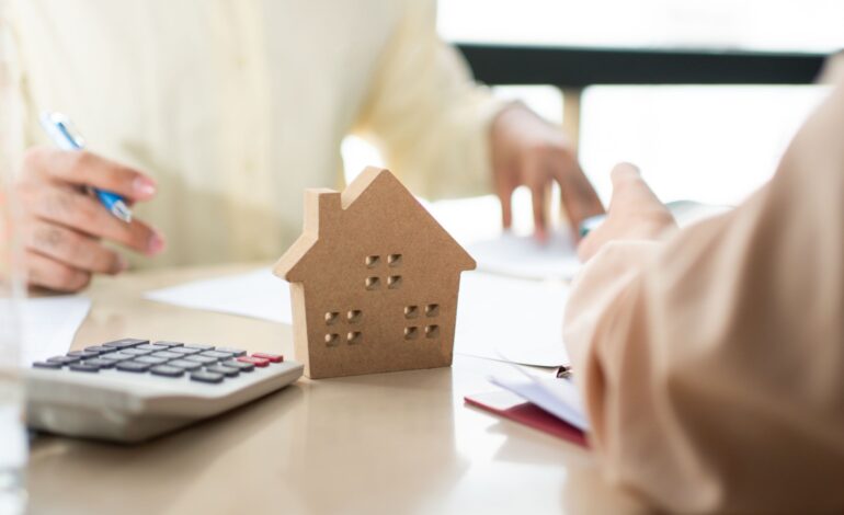 Klient podpisuje dokument pożyczki na zakup domu z agentem nieruchomości lub prawnikiem. Agent nieruchomości i klient podpisujący umowę kupna domu. Koncepcja ubezpieczenia lub pożyczki nieruchomości