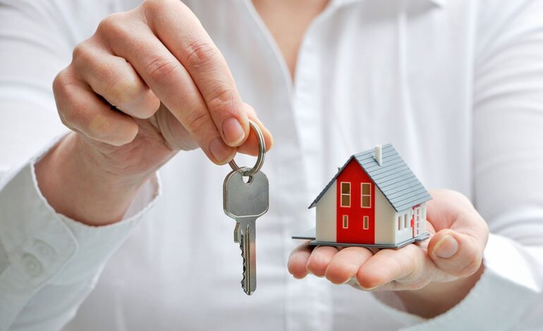 Agent nieruchomości z modelem domu i kluczami