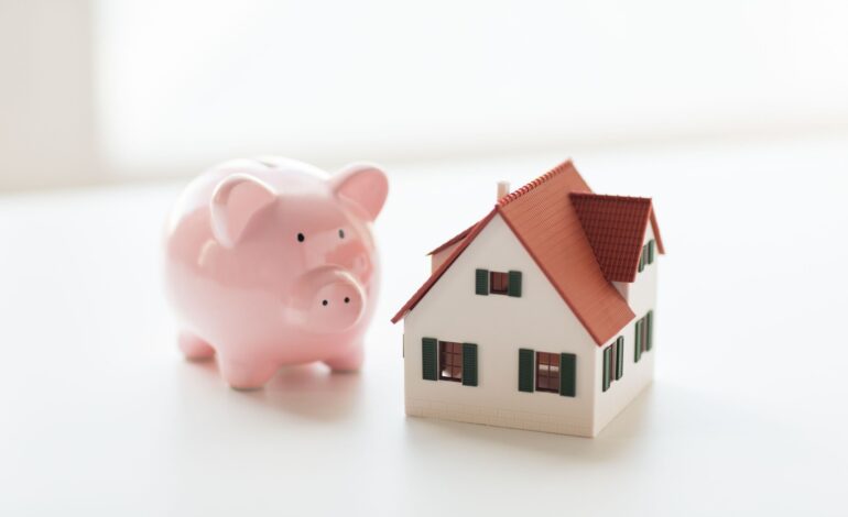 Koncepcja budynku, kredytu hipotecznego, inwestycji, nieruchomości i nieruchomości - zbliżenie modelu domu lub domu i skarbonki
