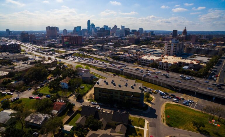 Urban Sprawl Cityscape Skyline z autostradą międzystanową I-35 ruchliwy ruch w słoneczny dzień w letnim rozwijającym się mieście fotografia lotnicza centrum miasta