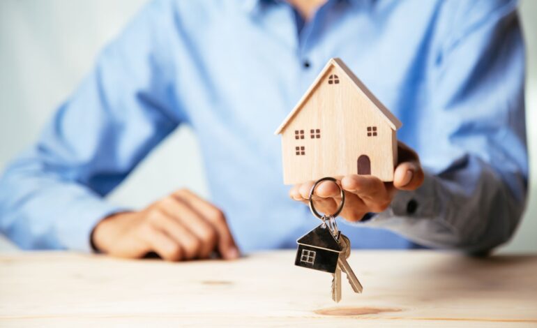Model domu z agentem nieruchomości i klientem omawiającym umowę kupna domu, ubezpieczenia lub kredytu na nieruchomości, koncepcja nieruchomości.